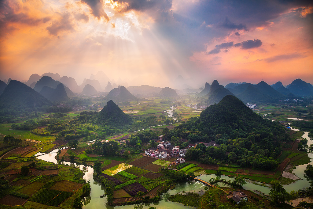 Light beams piercing the sky as seen from the top of Cuipingshan Hill in Yangshuo, China. It is a bit of a tricky climb to get to the top, so I had the place all to myself this evening. The beams lasted for about 20 minutes and were moving from place to place.