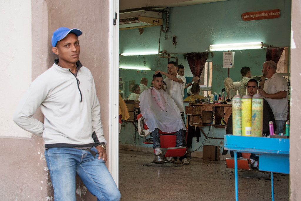 A man gets his haircut in a barber shop in Sancti Spiritus as a waiting customer stands outside. This photo has haunted me since I took it, as I wish I had taken more variantions, including making the man outside in focus and blurring the barber shop, or shooting at f/8 and getting everything in focus. I still like it though, and think it tells the story. Photographed with a Tamron 70-200 f/2.8 at 1/30 and f/5.6.